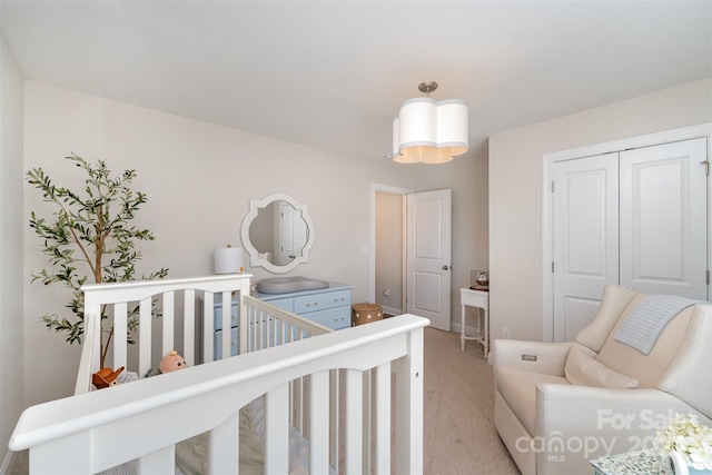 bedroom with light carpet, a closet, and a nursery area