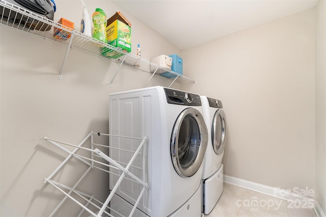 washroom with washer and clothes dryer, baseboards, and light tile patterned floors