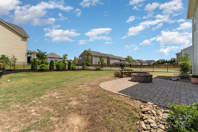 view of yard with a residential view, a fire pit, and a patio area