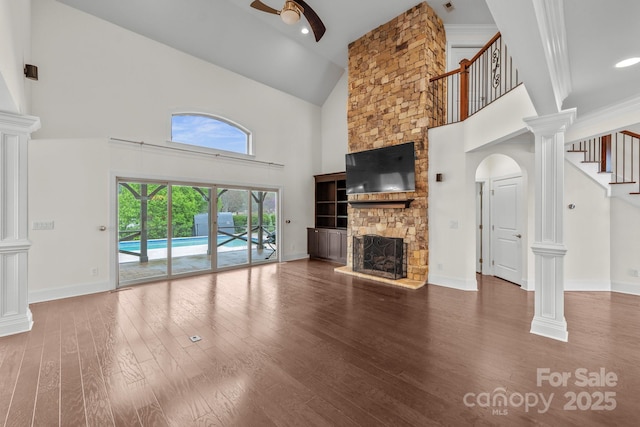 1012 Harper Lee Dr, Newton, NC 28658 - unfurnished living room featuring stairway, high vaulted ceiling, ceiling fan, a stone fireplace, and wood finished floors