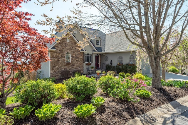 59 Carriage Highlands Ct, Hendersonville, NC 28791 - view of front facade with stone siding, stucco siding, and a chimney