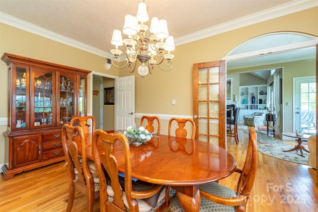 59 Carriage Highlands Ct, Hendersonville, NC 28791 - dining space featuring ornamental molding, a textured ceiling, a notable chandelier, and light wood-type flooring