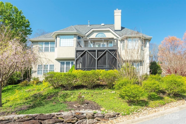 59 Carriage Highlands Ct, Hendersonville, NC 28791 - back of property with stucco siding, a chimney, and a balcony