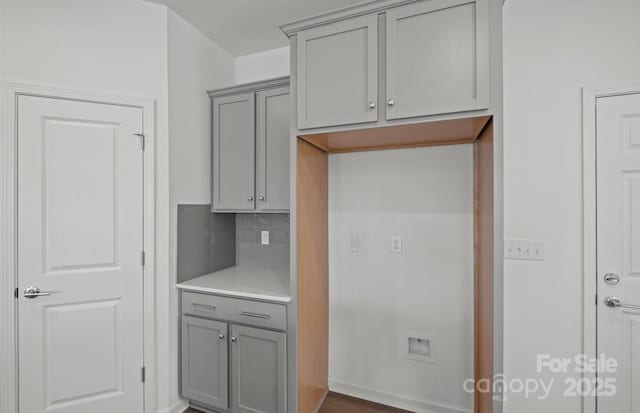 kitchen with light countertops, gray cabinetry, and backsplash