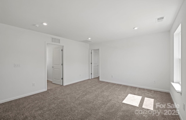 spare room featuring carpet, visible vents, and recessed lighting