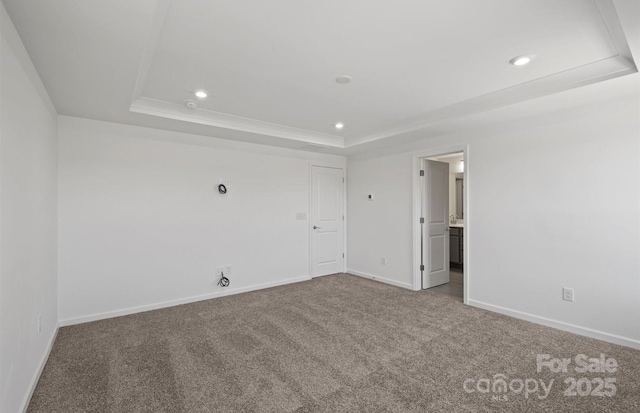 carpeted empty room with baseboards, recessed lighting, and a raised ceiling