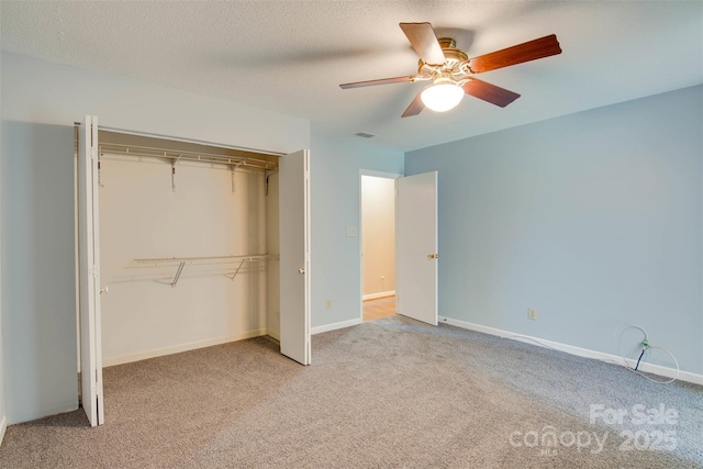 unfurnished bedroom featuring carpet floors, baseboards, ceiling fan, and a closet