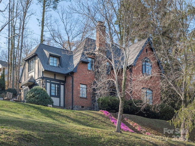 250 Kimberly Ave, Asheville, NC 28804 - english style home featuring a shingled roof, a chimney, a front yard, and brick siding