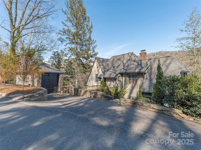 250 Kimberly Ave, Asheville, NC 28804 - view of side of home with a chimney, stucco siding, an outdoor structure, and driveway