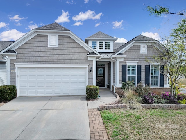 view of front of property with concrete driveway, a shingled roof, and an attached garage