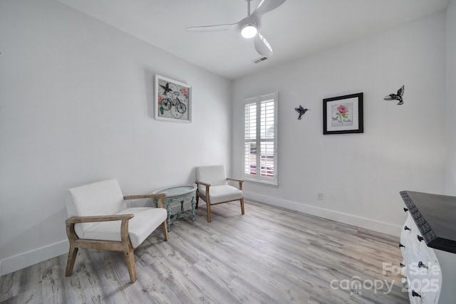 sitting room featuring wood finished floors, ceiling fan, baseboards, and visible vents