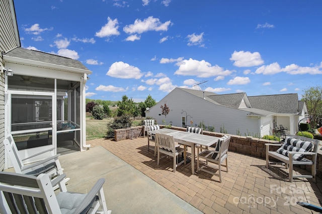view of patio featuring outdoor dining space and a sunroom