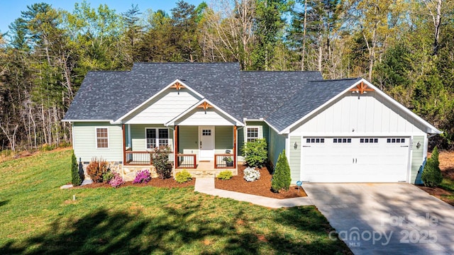 view of front of home featuring concrete driveway, board and batten siding, a front lawn, a garage, and covered porch