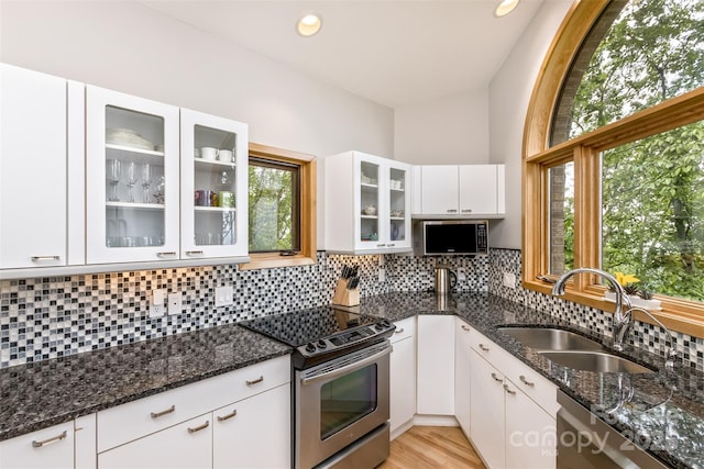 212 Chestnut Forest Rd, Fairview, NC 28730 - kitchen with stainless steel appliances, a sink, dark stone counters, white cabinetry, and decorative backsplash