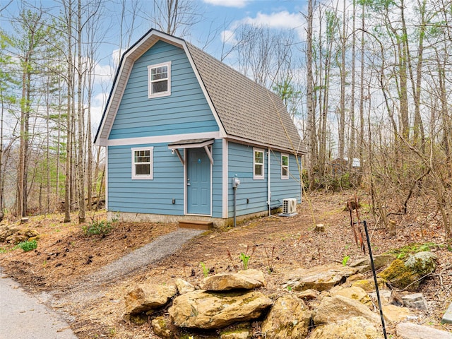 dutch colonial featuring roof with shingles and a gambrel roof