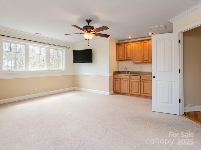 unfurnished living room featuring visible vents, a ceiling fan, light carpet, a sink, and baseboards