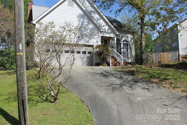 9915 Lottie Ln, Charlotte, NC 28262 - view of front facade with concrete driveway, a garage, fence, and a chimney
