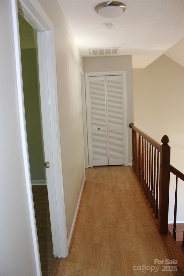 9915 Lottie Ln, Charlotte, NC 28262 - hallway with baseboards, an upstairs landing, light wood-style flooring, and visible vents