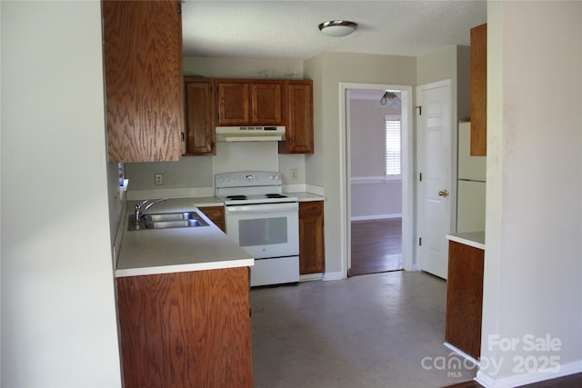 9915 Lottie Ln, Charlotte, NC 28262 - kitchen with light countertops, white appliances, under cabinet range hood, a sink, and brown cabinetry