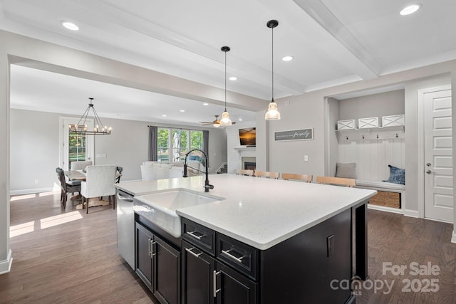 4195 Island Fox Ln, Denver, NC 28037 - kitchen with stainless steel dishwasher, dark cabinetry, a sink, a fireplace, and open floor plan