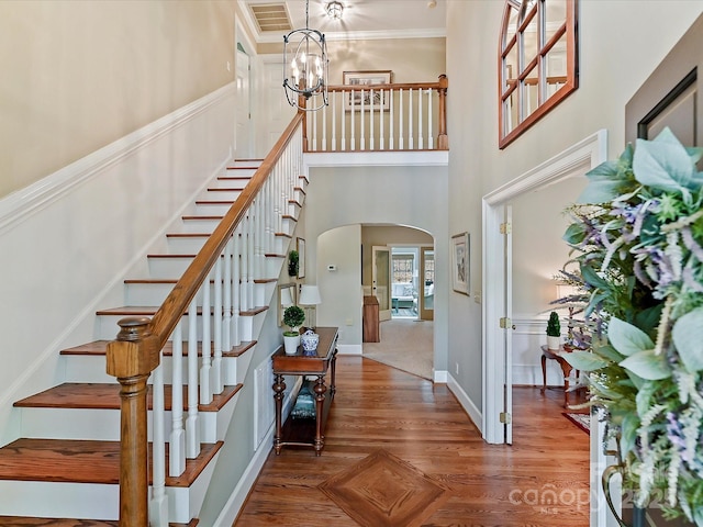 2313 Beechwood Dr, Waxhaw, NC 28173 - foyer with arched walkways, stairs, a chandelier, a high ceiling, and wood finished floors