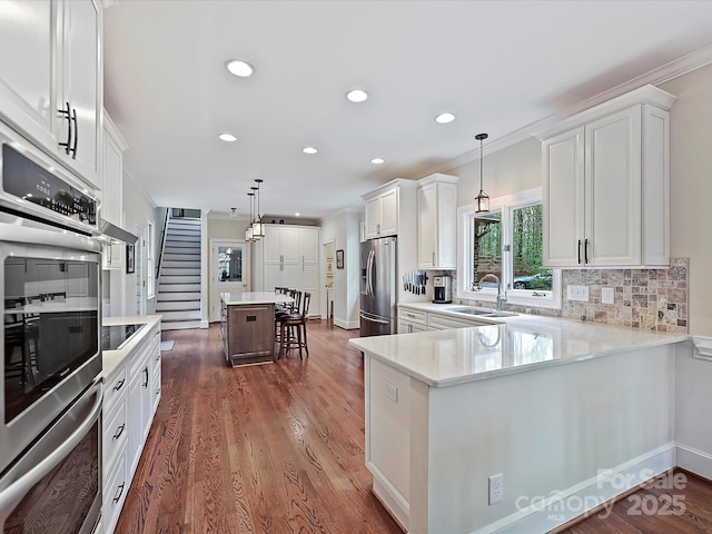 2313 Beechwood Dr, Waxhaw, NC 28173 - kitchen with appliances with stainless steel finishes, a sink, white cabinetry, light countertops, and recessed lighting