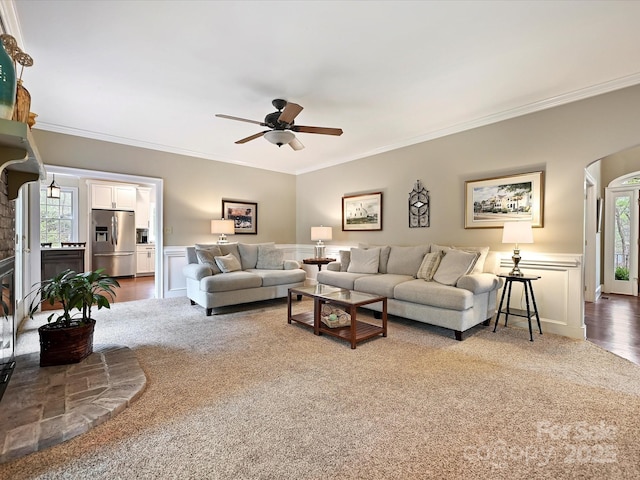 2313 Beechwood Dr, Waxhaw, NC 28173 - carpeted living room with ceiling fan, crown molding, plenty of natural light, a wainscoted wall, and arched walkways