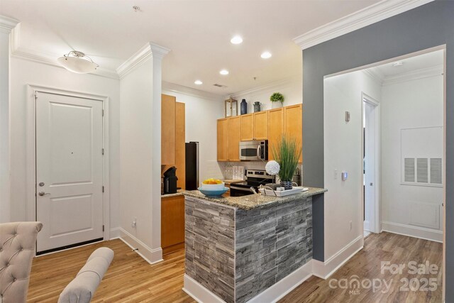 kitchen with light wood finished floors, decorative backsplash, baseboards, ornamental molding, and appliances with stainless steel finishes