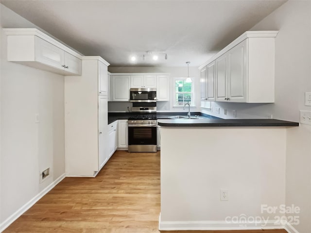 4222 Mt Gallant Rd, Rock Hill, SC 29732 - kitchen featuring a peninsula, dark countertops, appliances with stainless steel finishes, white cabinetry, and a sink