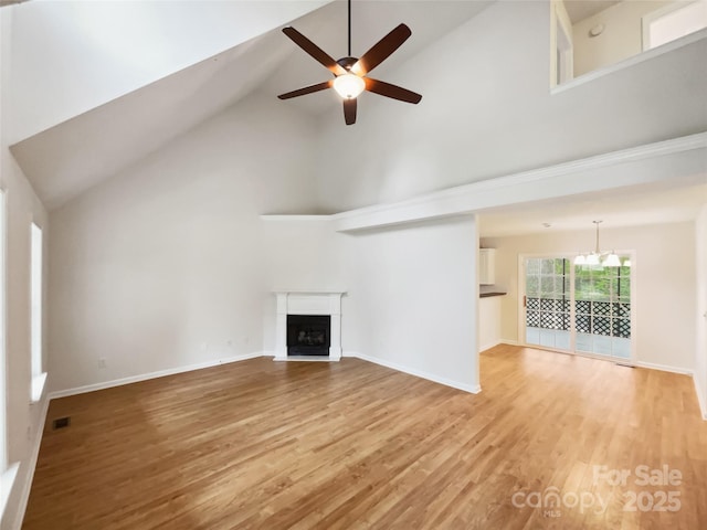 4222 Mt Gallant Rd, Rock Hill, SC 29732 - unfurnished living room with high vaulted ceiling, ceiling fan with notable chandelier, light wood-style floors, visible vents, and a fireplace
