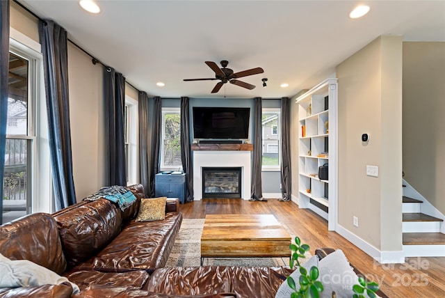 living room featuring recessed lighting, a fireplace, a ceiling fan, and wood finished floors