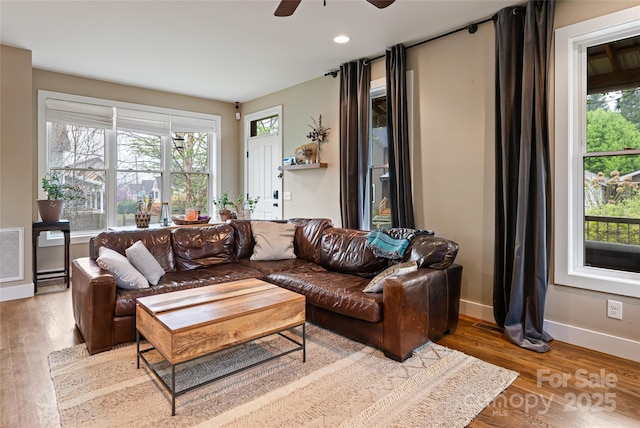 living area with ceiling fan, baseboards, visible vents, and wood finished floors