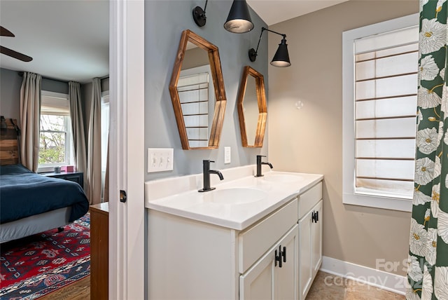 bathroom with a sink, double vanity, ensuite bath, and a ceiling fan
