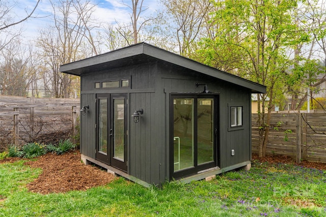 view of outbuilding featuring an outdoor structure and fence