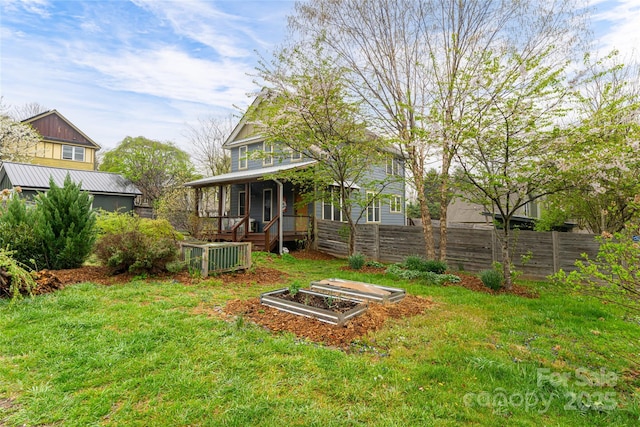 view of yard featuring a garden, central AC, fence, and a porch