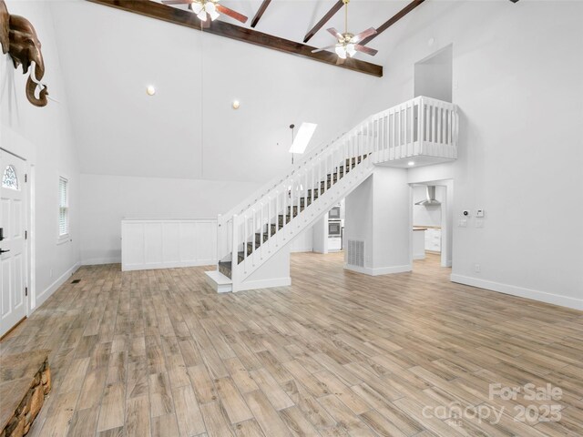373 Vineyard Rd, Tryon, NC 28782 - unfurnished living room featuring ceiling fan, high vaulted ceiling, stairway, wood finished floors, and baseboards