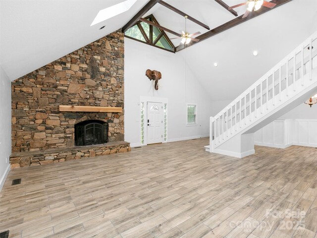 373 Vineyard Rd, Tryon, NC 28782 - unfurnished living room with a skylight, stairway, high vaulted ceiling, a stone fireplace, and ceiling fan