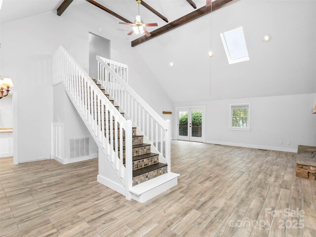 373 Vineyard Rd, Tryon, NC 28782 - staircase with high vaulted ceiling, beam ceiling, wood finished floors, baseboards, and a skylight
