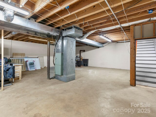 373 Vineyard Rd, Tryon, NC 28782 - unfinished basement featuring a wood stove, heating unit, and stairway