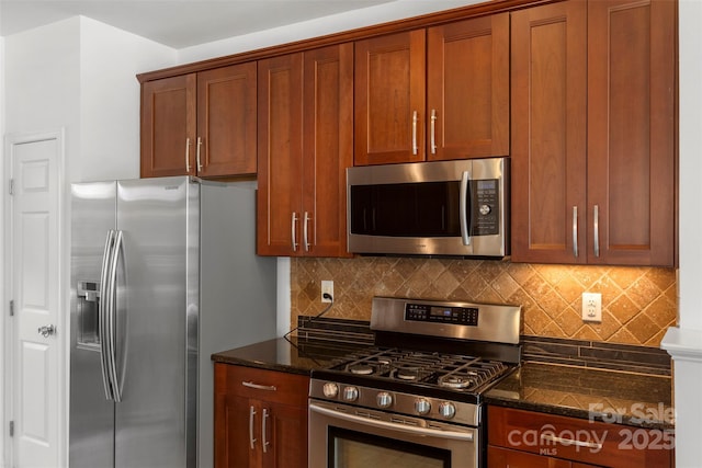 kitchen with dark stone counters, appliances with stainless steel finishes, and backsplash