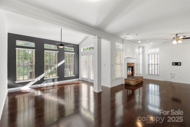 unfurnished living room featuring wood finished floors, baseboards, and a ceiling fan