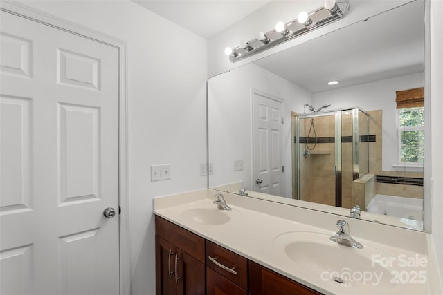 bathroom with double vanity, a sink, and a stall shower
