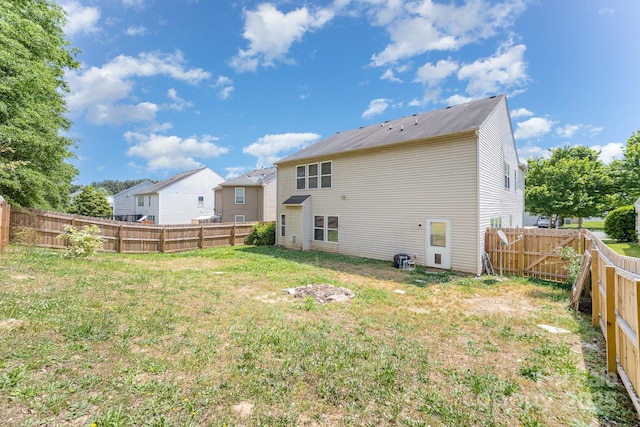 rear view of property with a yard and a fenced backyard