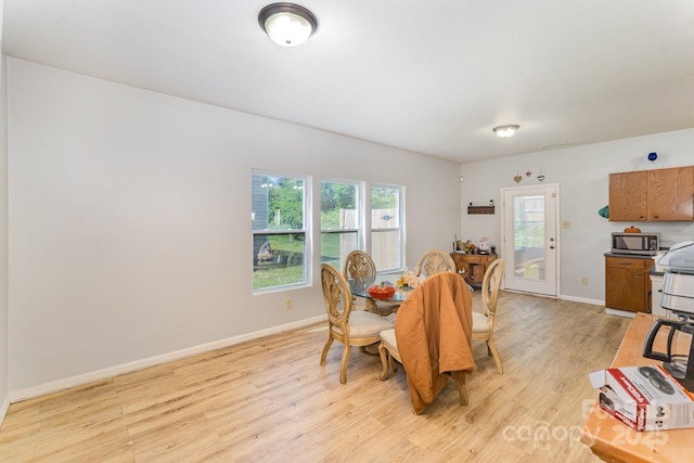 dining area featuring baseboards and light wood-type flooring