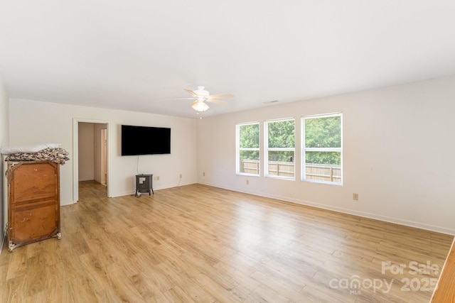 unfurnished living room with light wood-style flooring, baseboards, and ceiling fan