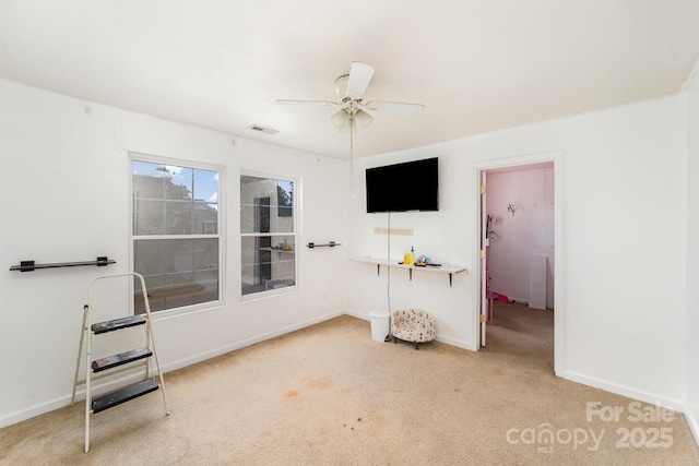 interior space featuring baseboards, a ceiling fan, and visible vents