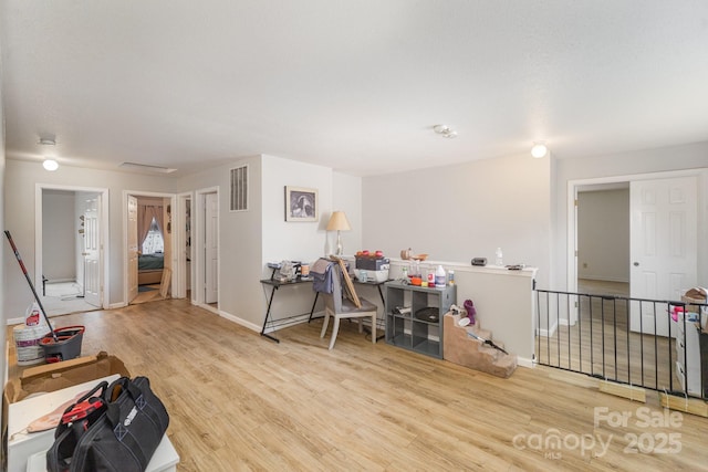 interior space with baseboards, visible vents, and wood finished floors