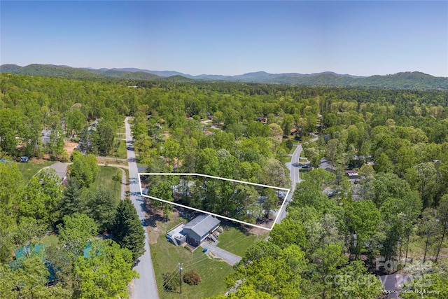 birds eye view of property featuring a wooded view and a mountain view
