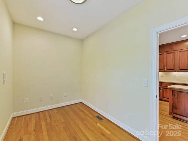 empty room featuring baseboards, visible vents, light wood-style floors, and recessed lighting