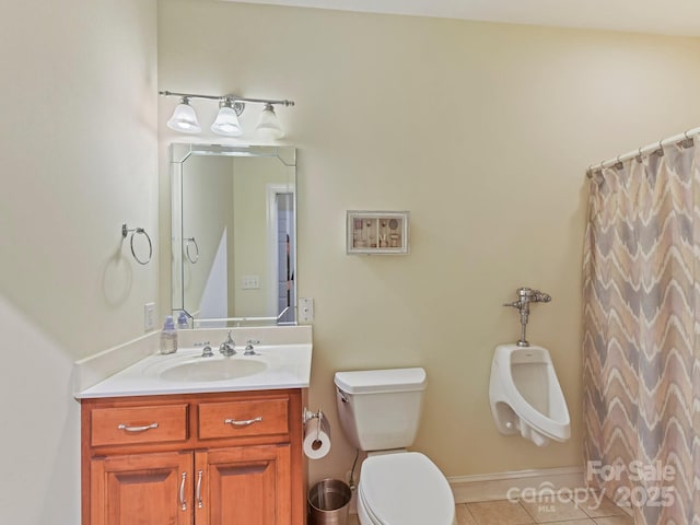bathroom with baseboards, toilet, tile patterned flooring, and vanity